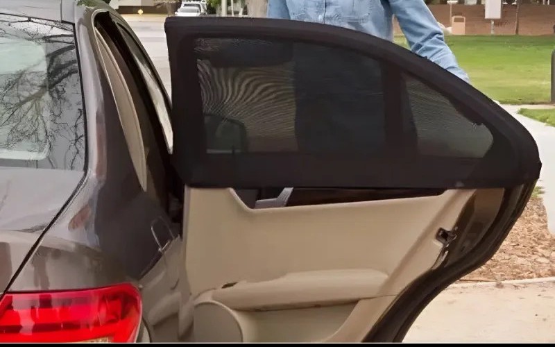 Una malla negra ya puesta sobre la ventana de una puerta de atrás de un auto