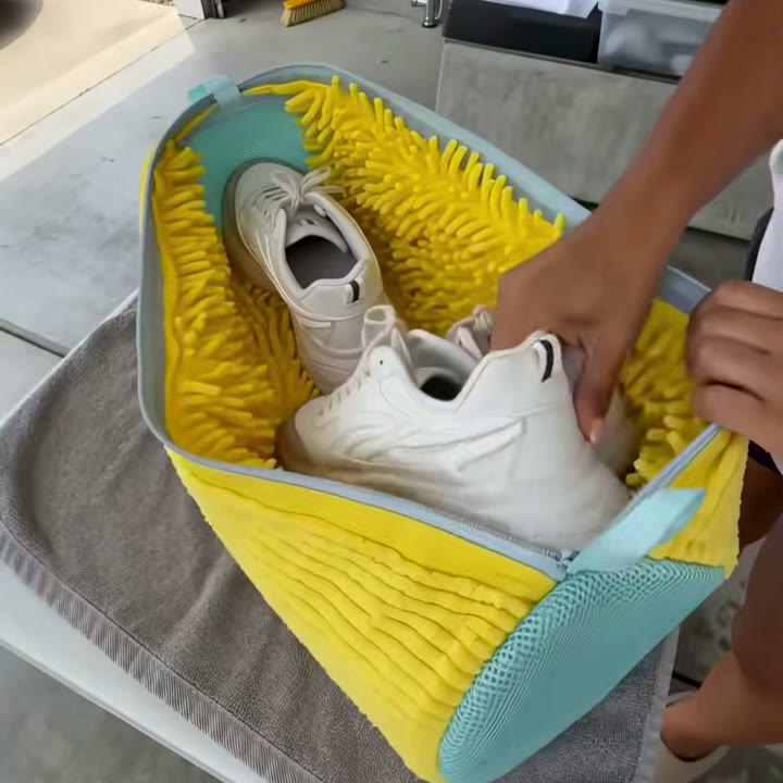 Manos metiendo un par de zapatillas blancas en la bolsa amarilla con flecos