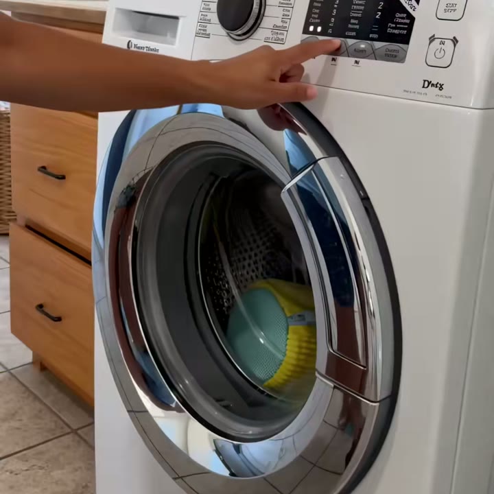 Mano encendiendo una lavadora de carga frontal con la bolsa adentro