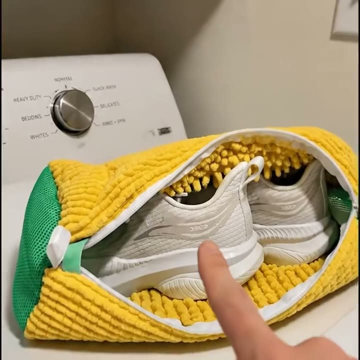 Bolsa amarilla con flecos y un par de zapatillas blancas adentro, sobre una lavadora