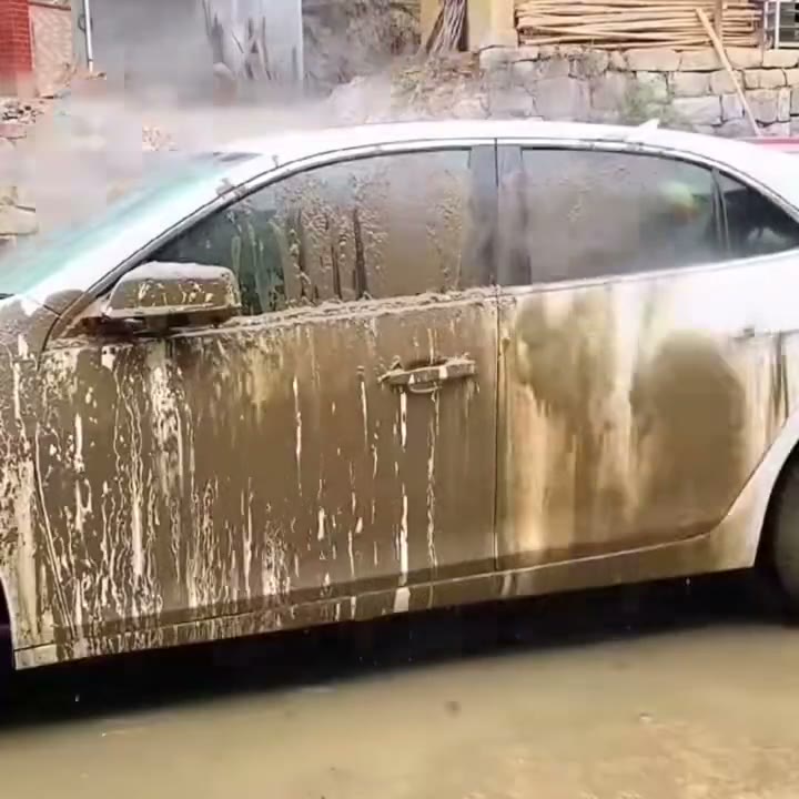 Auto con barro lavándose con la boquilla