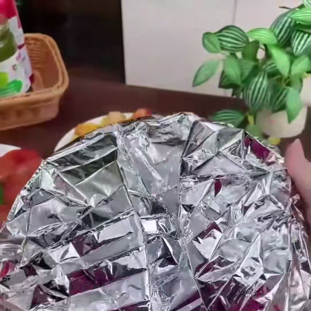 De cerca: tapa de aluminio arrugada puesta sobre un plato con comida (foto de un producto equivalente)