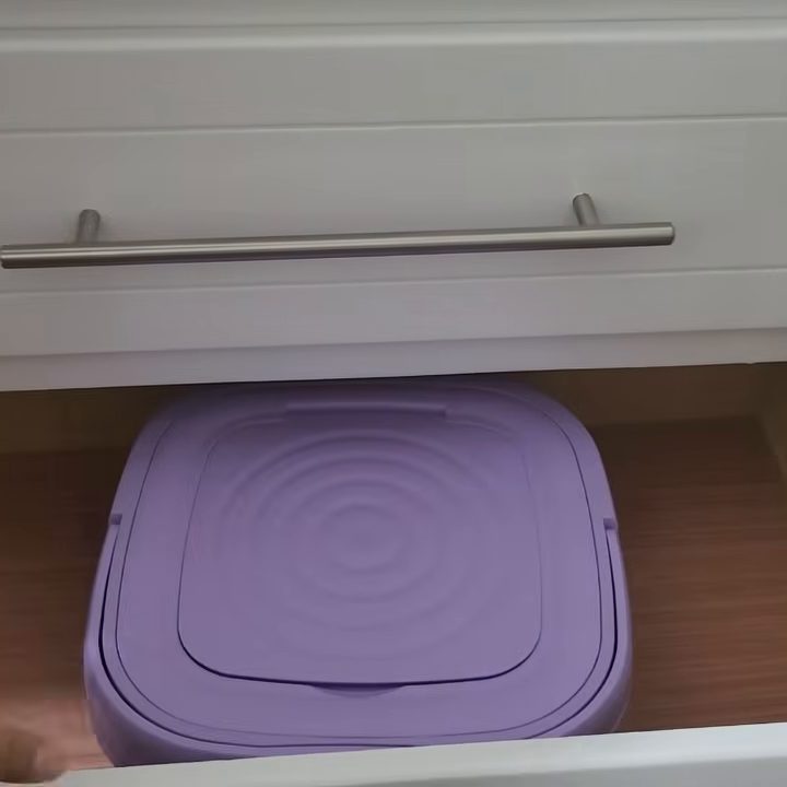 La mini lavadora plegada, baja y cuadrada, guardada dentro de un cajón