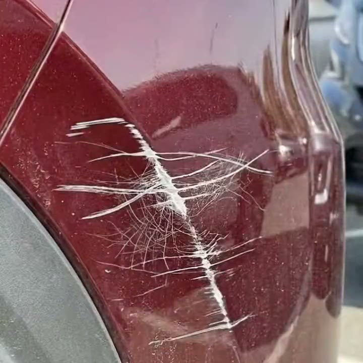 Paño amarillo puliendo un roce en el auto